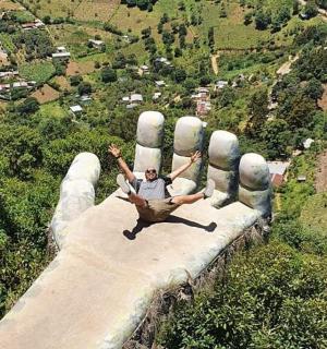一名男子躺在一只巨手上