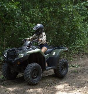 una persona que viatja en un quad per una carretera de terra