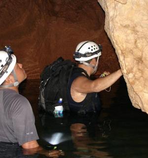 two people in the water in a cave