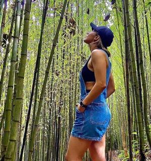 a woman is standing in a bamboo forest