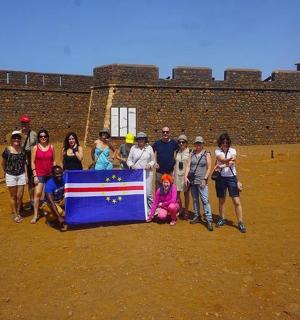 a group of people posing for a picture with a flag