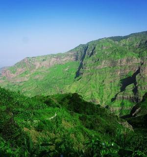 a view of a mountain with green vegetation
