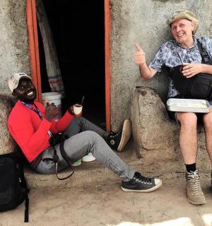 two men sitting outside of a doorway with