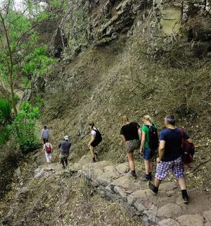 a group of people walking up a rocky mountain