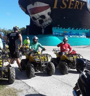 a group of people on atvs in front of a ship