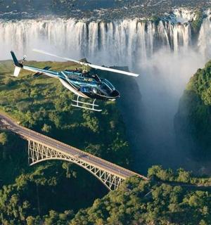 vrtulník letící nad mostem před vodopádem
