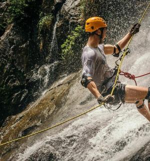 一名男子被绑在瀑布上的绳索上