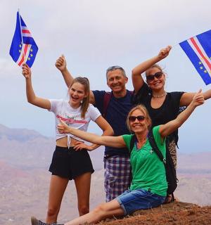 skupina lidí držících vlajky na vrcholu hory