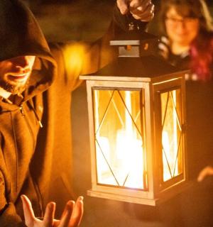 一名身着尼姑服装的男子手持灯笼