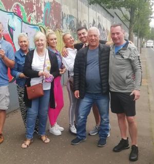 a group of people standing next to a wall