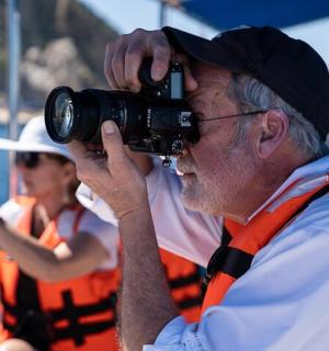 a man taking a picture with a camera on a boat