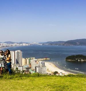 a group of people standing on a hill overlooking a beach