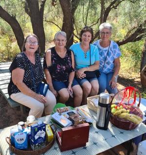 四个女人坐在野餐桌上