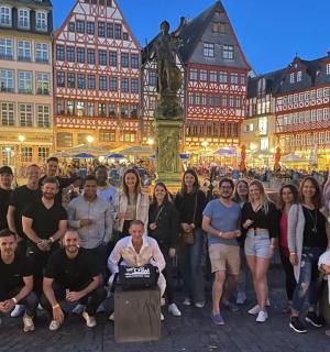 eine Gruppe von Menschen, die in einer Stadt für ein Foto posieren