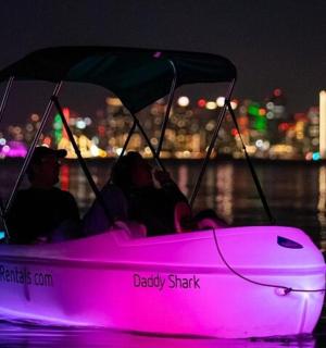 dva lidé v růžové lodi ve vodě v noci