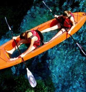 两个人在水中的黄色皮划艇上