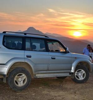 山の頂上に駐車された銀色のSUV