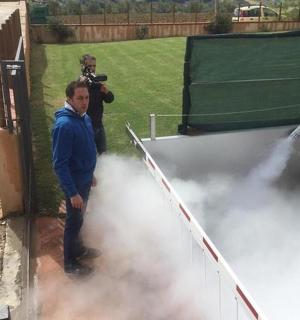 一名男子手持相机站在烟雾前