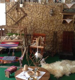 místnost se stolem a židlemi a kamennou zdí