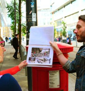 一名男子正在将一张照片放在报纸架上