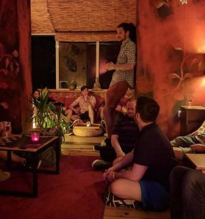 a group of people sitting in a room with a man standing on the wall