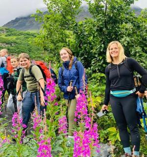 skupina lidí procházejících se květinovým polem