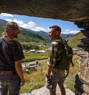 两个男人站在山洞里,向窗外望去