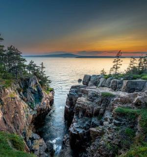 岩石海岸线附近水面上的日落