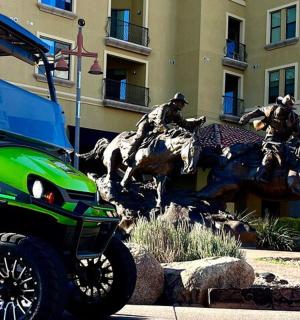 two horses jumping over a statue of two men on horses