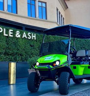 a green golf cart parked in front of a building