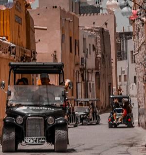 一群高尔夫球车沿着城市街道行驶