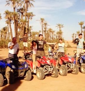 skupina ljudi, ki stojijo okoli štirikolesnikov v umazaniji