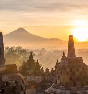 a painting of a temple with the sun in the background