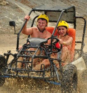 dva muži jedoucí na čtyřkolce v bahně