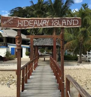 a wooden walkway to a beach with a sign