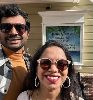 a man and a woman standing in front of a house