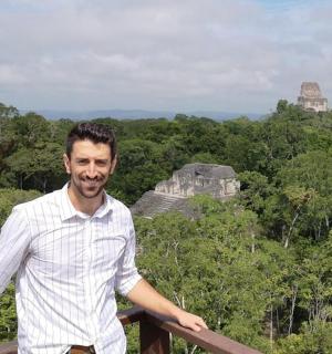 a man standing in front of the mayan ruins