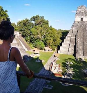 a woman standing on a balcony at the mayan pyramid