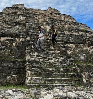 two people standing on top of a stone wall