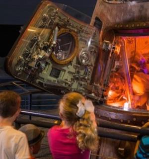 skupina lidí dívajících se na vesmírnou stanici