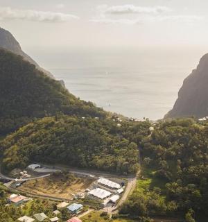 an aerial view of a valley with mountains and the ocean