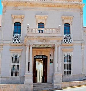 bílá budova s balkonem na střeše