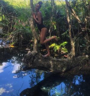 一位妇女坐在河边的一棵树上