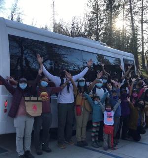 a group of people standing in front of a bus