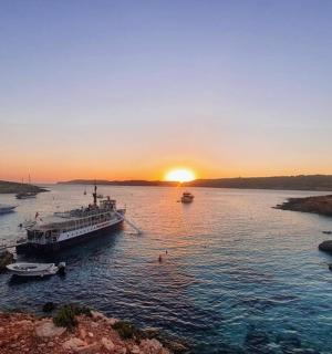 Skupina lodí ve vodě při západu slunce