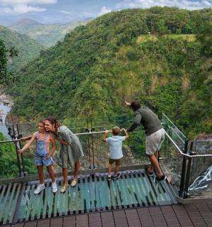 a group of people standing on a walkway looking at a mountain