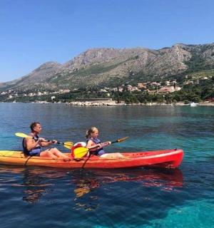 一名男子和一名儿童在水中的皮划艇上