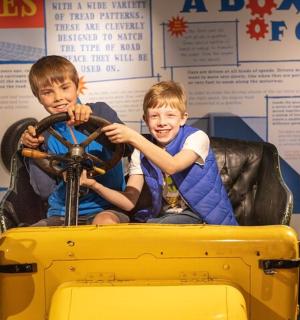 two young boys playing with a toy car