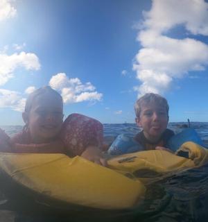 两个孩子在水中乘坐木筏