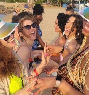 a group of women in hats on the beach